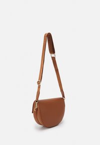 Borsa a tracolla in pelle marrone con forma arrotondata, dotata di una tracolla texturizzata e dettagli in oro. Chiusura con zip laterale.