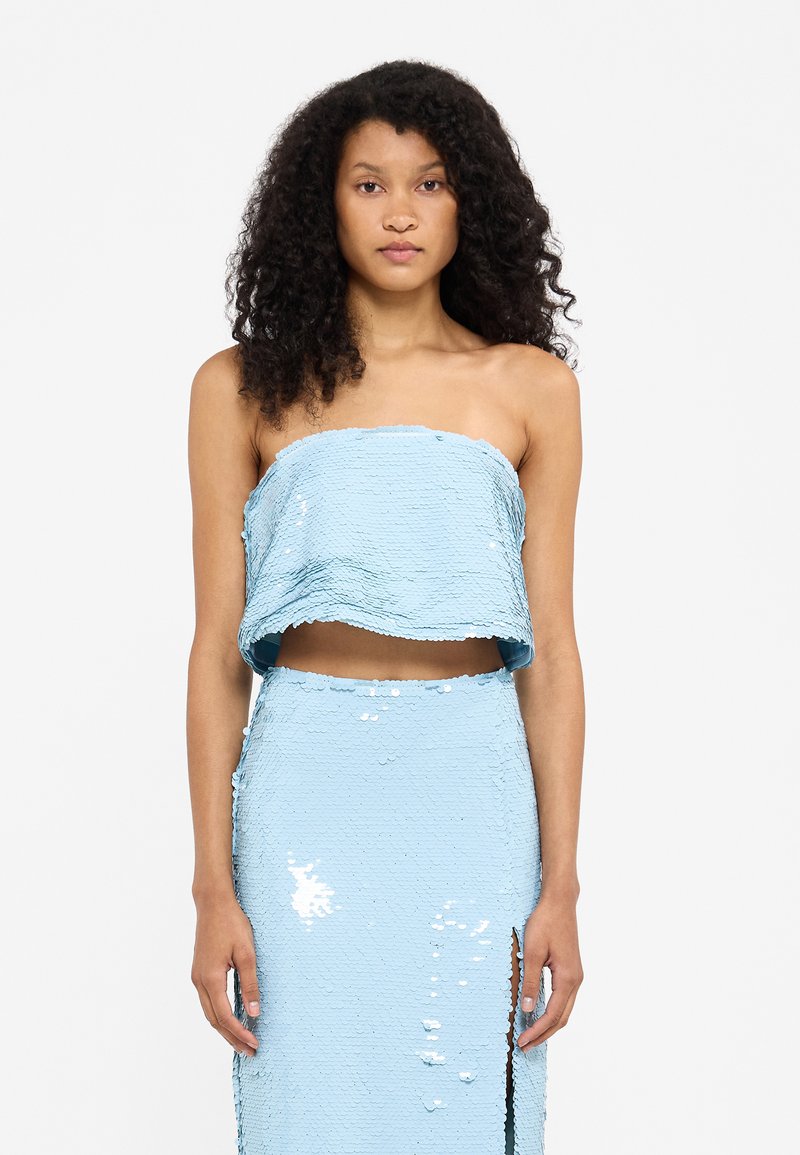 Lichtblauw twee-delig outfit met een strapless cropped top en een bijpassende rok, beiden versierd met glanzende pailletten en een zijsplit.