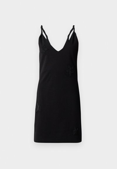 Musta hihaton mekko, jossa on V-pääntie, valmistettu pehmeästä kankaasta, ja etupuolella on koristeellisia helmistä tehtyjä tähden aplikaatioita.