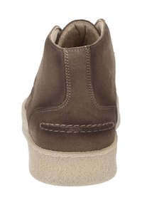 Stivale alla caviglia in suede marrone con forma arrotondata, suola beige texturizzata e semplice dettaglio di cucitura sul tallone. Rivestimento interno liscio.