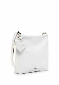 Sac crossbody en cuir blanc avec une texture lisse, doté d'une étiquette détachable en forme de cœur et d'un accent en métal argenté.