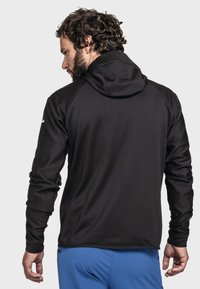 Schwarzer Kapuzenpullover mit langen Ärmeln, aus einem glatten Stoff gefertigt. Hat ein figurnahes Design und ein dezentes Logo auf der linken Schulter.