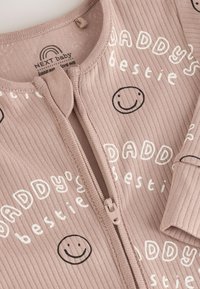 Rosa gerippter Jumpsuit mit Reißverschluss, bedruckt mit dem Text "Daddy's bestie" und Smiley-Gesichtern. Verfügt über einen runden Ausschnitt und lange Ärmel. Weicher Stoff.