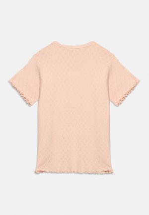 Top lavorato a maglia rosa chiaro a maniche corte con un delicato motivo a diamante e bordi arricciati sulle maniche e sull'orlo, mostrato da dietro.