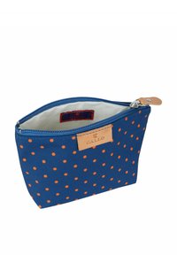 Borsetta di tessuto blu con pois arancioni, chiusura con zip, dettaglio in pelle con etichetta del marchio all'interno e fodera interna bianca.