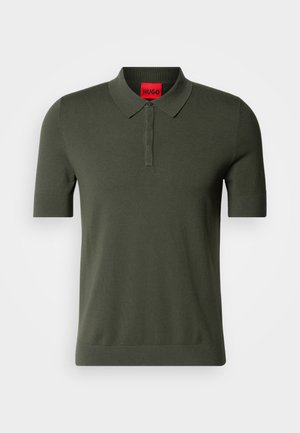 Olíva zöld, rövid ujjú pólóing kötött anyagból. Puha gallérral, három gombos pattenttal és piros logós címkével a nyaknál.