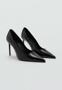 Zapatos de tacón alto de cuero negro con punta afilada y diseño elegante. Presentan una textura suave y un tacón de aguja para mayor altura.