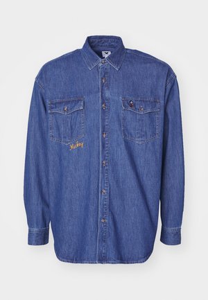 Denimskjorte i mørkeblå med lange ærmer, to frontlommer, knaplukning og broderet gult tekst "Mickey" på venstre lomme.