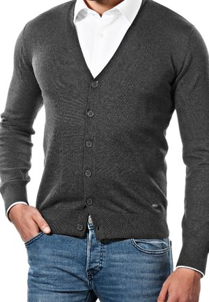 Szary dzianinowy kardigan z dekoltem w serek, zapinany na guziki, z prążkowanymi mankietami. W zestawieniu z niebieskimi dżinsami. Gładka faktura, klasyczny krój.