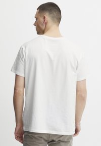White cotton t-shirt with short sleeves, crew neck, and a smooth texture, featuring a simple, minimalistic design.