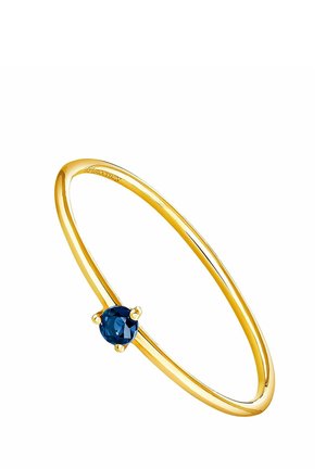 Delgado anillo de oro con una sola piedra preciosa redonda azul oscuro, montada en un engaste de tres puntas sobre un fondo blanco.