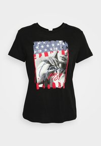 Sort bomulds t-shirt med et grafisk design af et kvindeportræt, farverne fra det amerikanske flag i blå, rød og hvid, samt stiliseret tekst "1984."