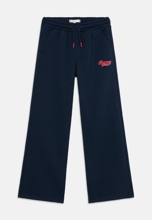 Pantalons de survêtement bleu marine avec une taille élastique et un cordon rouge. Présente un petit logo rouge "Tommy" sur la jambe gauche et des poches latérales.