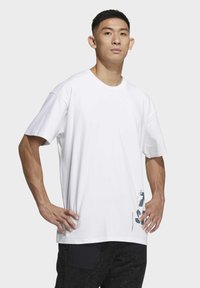 T-shirt bianca in cotone con collo tondo, maniche corte e stampa grafica grigia sul lato inferiore. Design basic e dalla vestibilità rilassata.