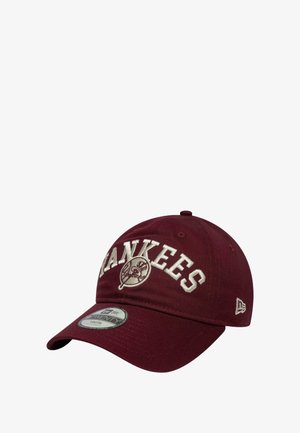 Cappello bordeaux con visiera curva, con ricamo bianco "YANKEES" e toppa del logo. Realizzato in tessuto resistente con fori di ventilazione.