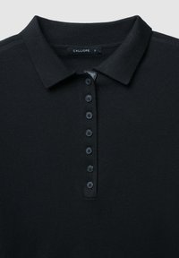 Polo shirt nera realizzata in tessuto testurizzato, dotata di colletto e di una patta con sei bottoni. L'etichetta indica la taglia 'S'.