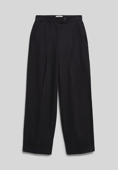 Pantalon noir taille haute à jambes larges avec fermeture par bouton et zip, plis devant et poches latérales sur fond gris.
