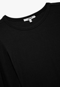 Schwarzes Baumwoll-T-Shirt mit rundem Halsausschnitt, kurzen Ärmeln, glatter Textur und einem Etikett mit Größenangaben. Minimalistisches Design.