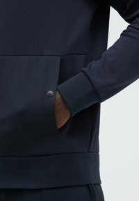 Dark navy sweatshirt featuring a kangaroo pocket, ribbed cuffs, and hem, made from soft, textured fabric with a smooth finish.