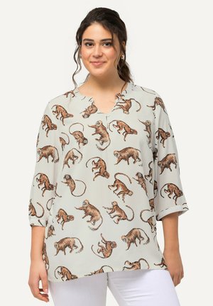 Blusa gris claro con un patrón de monos, con escote en V y mangas 3/4. Fabricada con una tela suave y ligera.