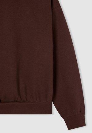 Felpa marrone con orlo e polsini a coste; tessuto morbido; presenta una vestibilità rilassata e un design con spalle scese.