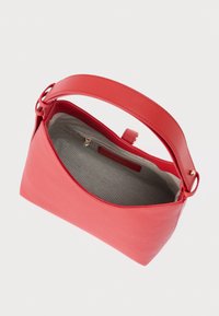 Czerwona skórzana torba o zaokrąglonym kształcie, gładkiej fakturze i płaskim uchwycie. Wnętrze wyłożone jasnoszarym materiałem z kieszonką na zamek.