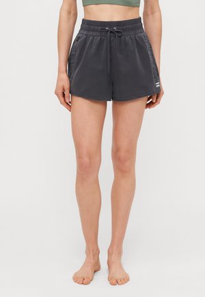 Dunkelgraue Sportshorts mit elastischem Bund und Kordelzug, ausgestattet mit Seitentaschen und fransigen Säumen. Logo-Akzent am Saum.