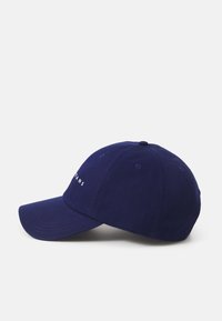 Căciulă de baseball bleu marin din bumbac, cu visieră curbată și text brodat alb pe față. Vizibile șase orificii de ventilație.