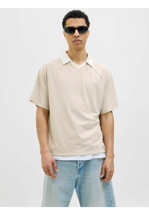 Beige, kortærmet polo skjorte med en hvid krave, der har et diskret lodret stribemønster og et logo på venstre bryst.
