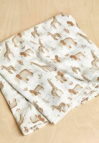 Cotton muslin blanket featuring a repeating pattern of brown animal silhouettes, including giraffes, elephants, and lions on a light background.