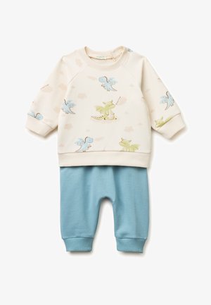 Béžový kojenecký top s dlouhým rukávem s modrými a zelenými motivy draka, doplněný světle modrými žebrovanými kalhotami.