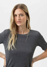Grijze, kortgebouwde top met een subtiel textuurpatroon en een ronde halslijn. Gemaakt van een zachte, rekbare stof, met een aansluitend ontwerp.