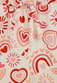 Shorts in cotone con vita regolabile tramite coulisse, con sfondo crema e motivo con cuori e arcobaleni in tonalità di rosa e rosso.