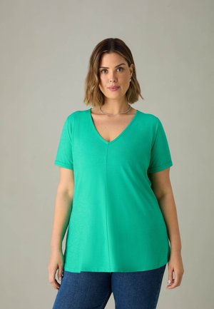T-shirt verde a scollo a V con maniche corte, realizzato in un tessuto morbido, caratterizzato da una vestibilità rilassata e spacchi laterali per un maggiore comfort.