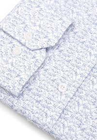 Biała koszula z powtarzającym się niebieskim wzorem konturów różnych zwierząt. Materiał jest lekki, z zapięciem na guziki przy kołnierzyku i mankietach.