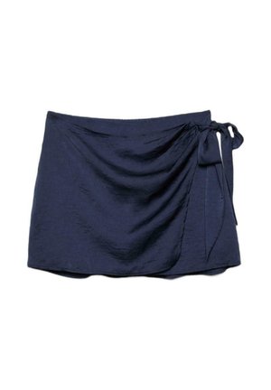 Jupe portefeuille bleu marine avec lien sur le côté, longueur courte, tissu légèrement texturé et drapé froncé sur un côté.