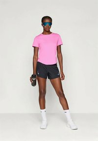 Ružový športový tričko, čierne šortky, biele ponožky a tenisky. Doplnky zahŕňajú modré slnečné okuliare a čiernu fľašu na vodu.