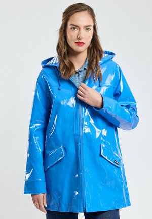 Imperméable bleu avec un fini brillant, doté d'une capuche, d'une fermeture éclair et de deux poches latérales. Fabriqué en matériau lisse et durable.