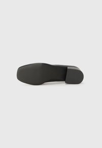 Black high-heeled shoe with a smooth, matte finish. Features a rounded toe, a block heel, and a ribbed rubber sole for grip.