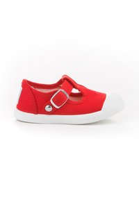 Zapato Mary Jane de lona roja con puntera de goma blanca, cierre con hebilla y suela texturizada. Presenta un diseño recortado en los lados.
