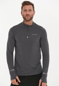 Grijze longsleeve pullover met een kwart-rits kraag, een soepele textuur en contrasterende streepdetaillering op de manchetten. Bevat een logo op de borst.