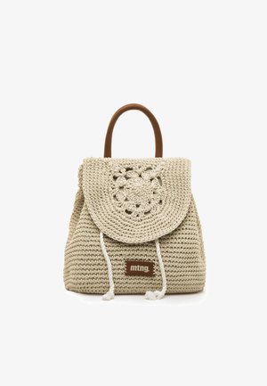 Beige geweven handtas met een flap met bloemenpatroon, bruine leren handvatten en witte trekkoorden. Bevat een merklabel in het bruin aan de voorkant.
