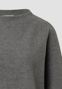 Gray knit sweater with a high neckline, featuring a soft texture and simple design. It has long sleeves and a relaxed fit.
