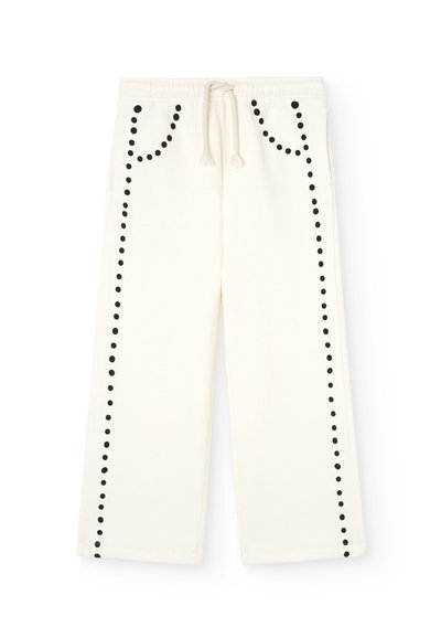 Løs pasform cremefarvede sweatpants med sort prikket mønster langs siderne, med elastisk talje og snørre.