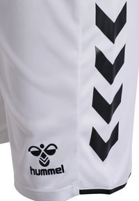Weiße Sportshorts mit schwarzen Chevron-Streifen an der Seite und einem schwarzen "hummel"-Logo nahe dem unteren Saum.