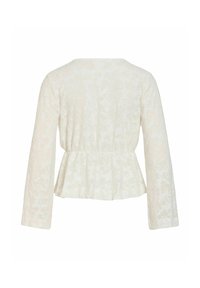 Blouse blanc cassé à manches longues avec une texture florale subtile, taille cintrée et ourlet style peplum, vue de dos sur fond blanc.