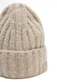 Berretto in lana lavorata a maglia beige con texture a coste e motivi a rombo, dotato di un risvolto.