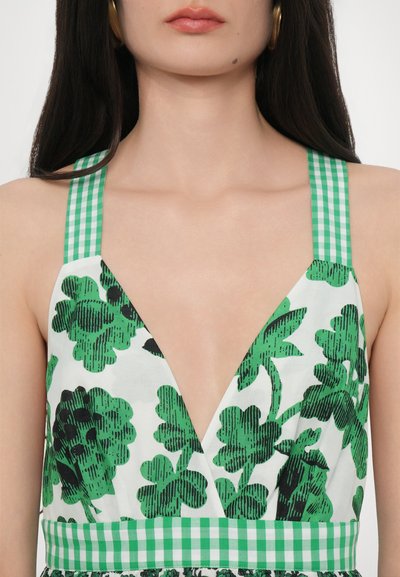 Groene en witte bloemenjurk met een diepe V-hals, gingham schouderbanden en gestructureerde bladvormen. Accentuated met een contrasterende geruite tailleband.