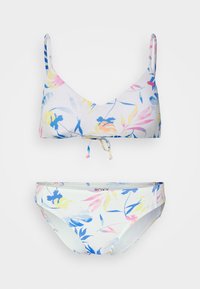 Conjunto de biquíni floral com fundo branco e folhas em tons pastel de rosa, azul e amarelo, alças ajustáveis e detalhe de nó à frente.