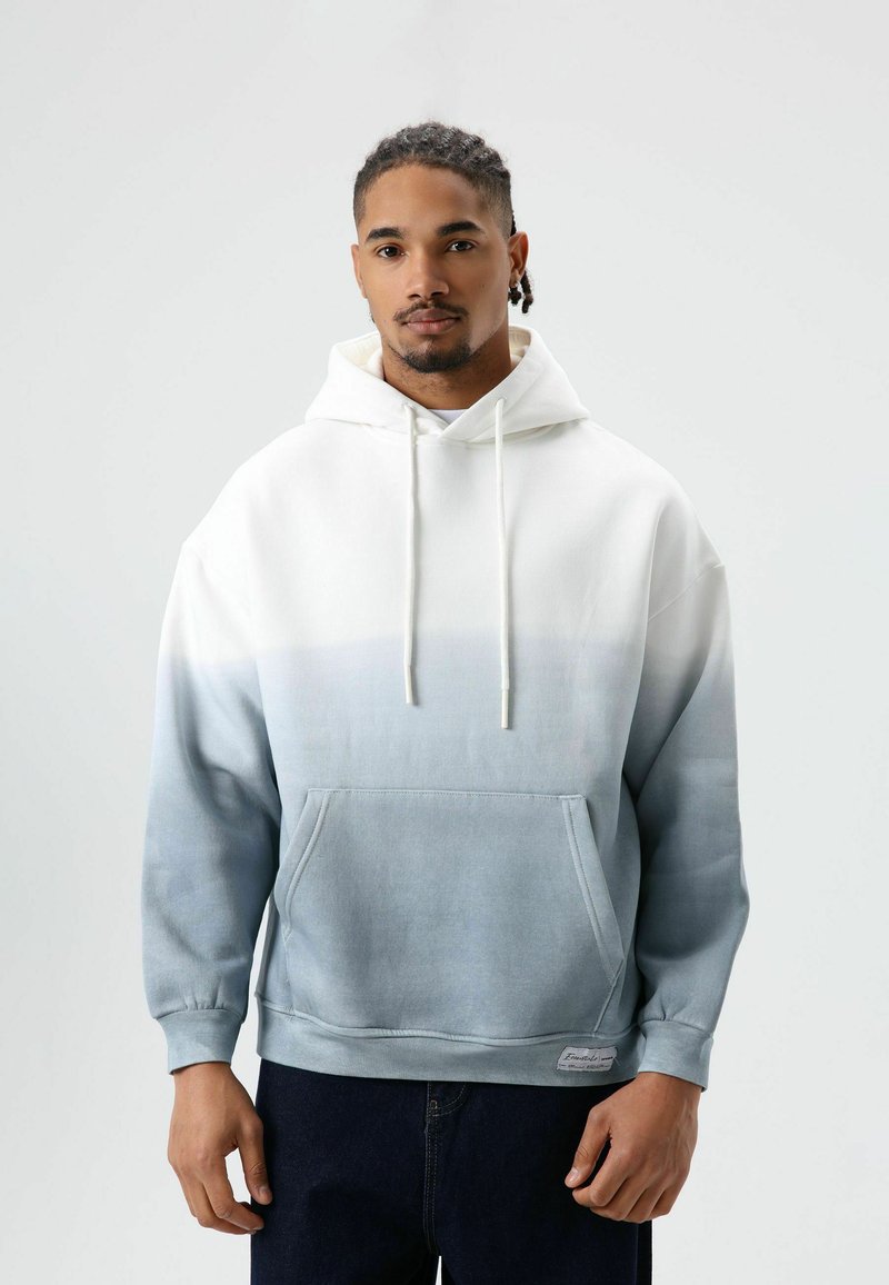 Capuchontrui met een verloopontwerp dat wit mengt naar lichtblauw. Voorzien van een voorzak en trekkoordsluitingen. Zachte stoftextuur.